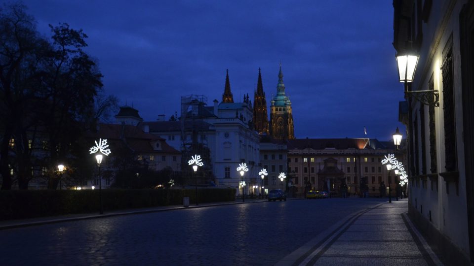 Přicházíme ke kandelábru na Hradčanském náměstí, světlo v něm lampář teprve rozžehne