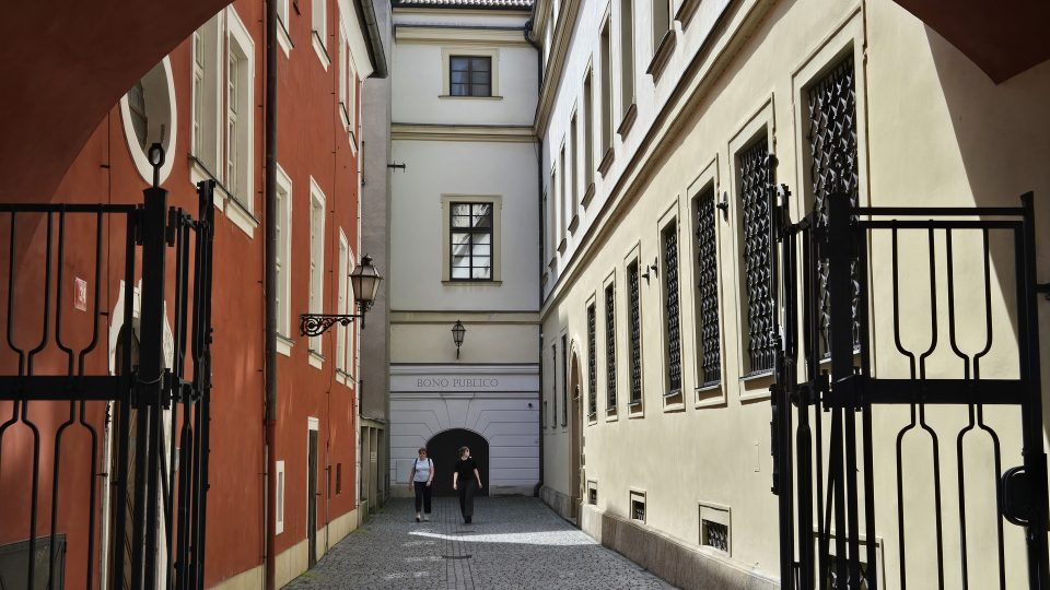 Cesta ke schodišti vede průchodem u Domu U Špuláků