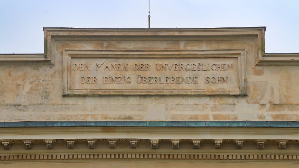 Uprostřed nad vítězným obloukem kolonády je umístěn německý nápis