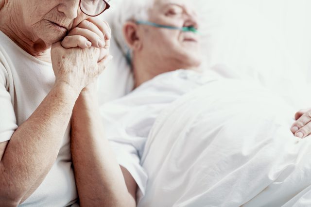 Partnerka drží muže za ruku v hospici | foto: Profimedia