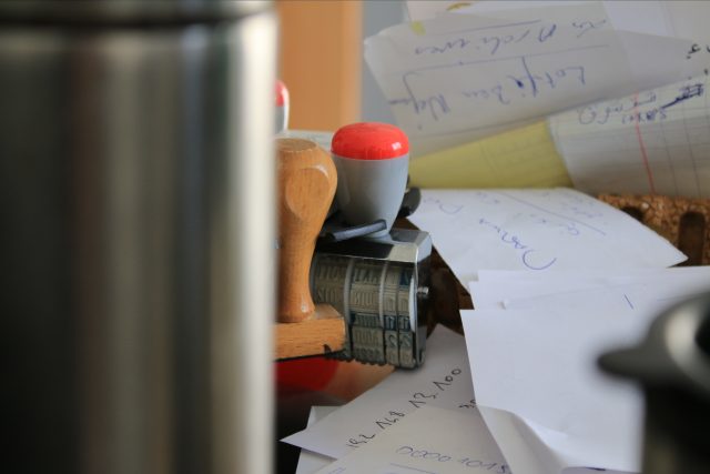 Pracovní stůl s razítky a papíry | foto: Unsplash,  Licence Unsplash